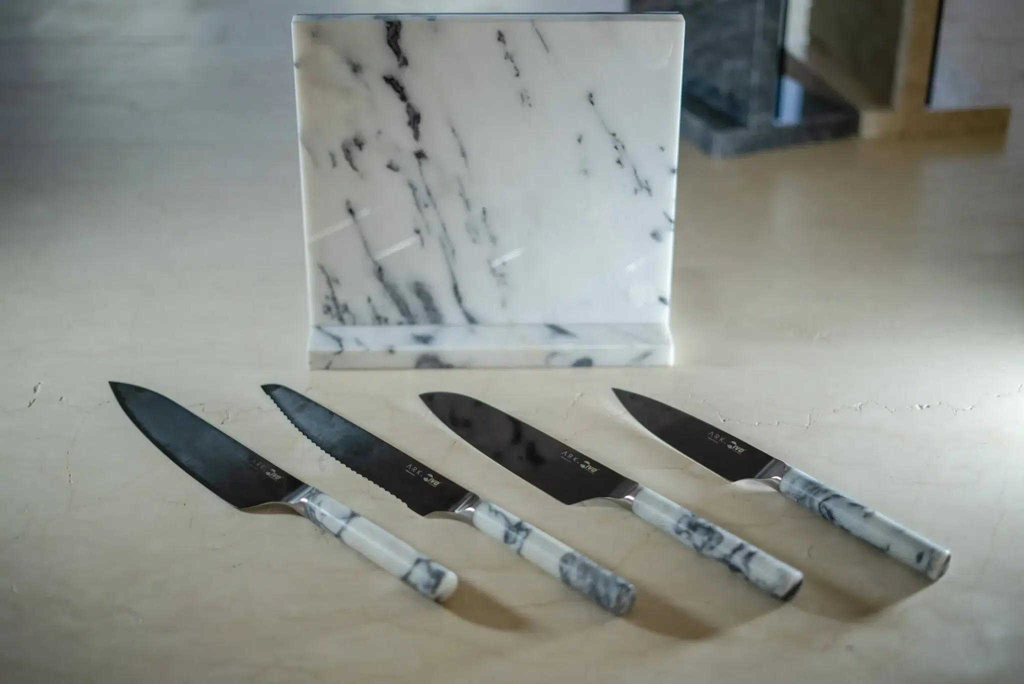 set of artisan knives with marble handles and a marble block, designed by manuel ruiz moriche ARK Architects to showcase the interplay of material, light, and craftsmanship