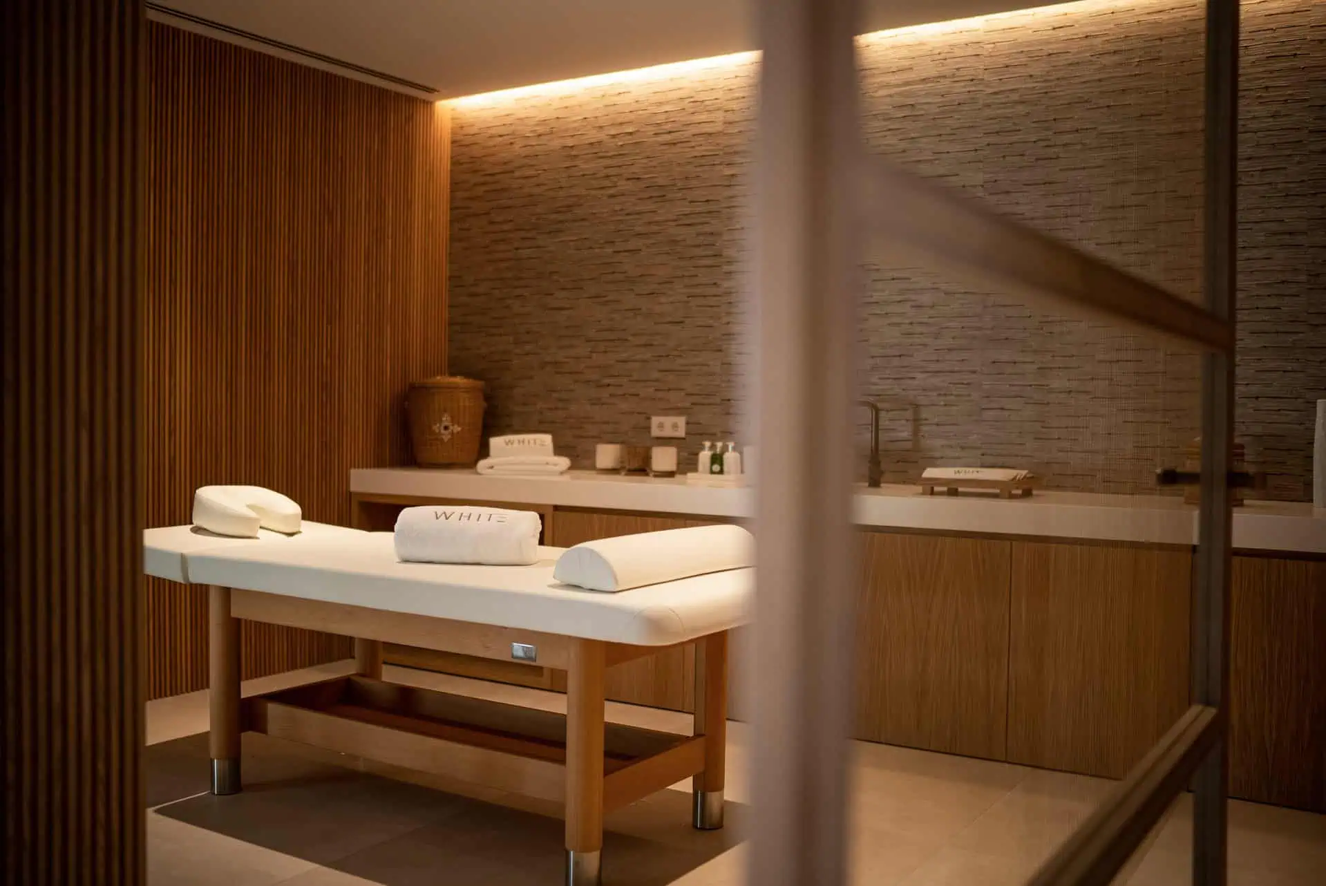 premium wellness massage room integrated in a luxury home by ARK Architects, featuring elegant wood and stone finishes for home wellbeing. vill white by manuel ruiz moriche