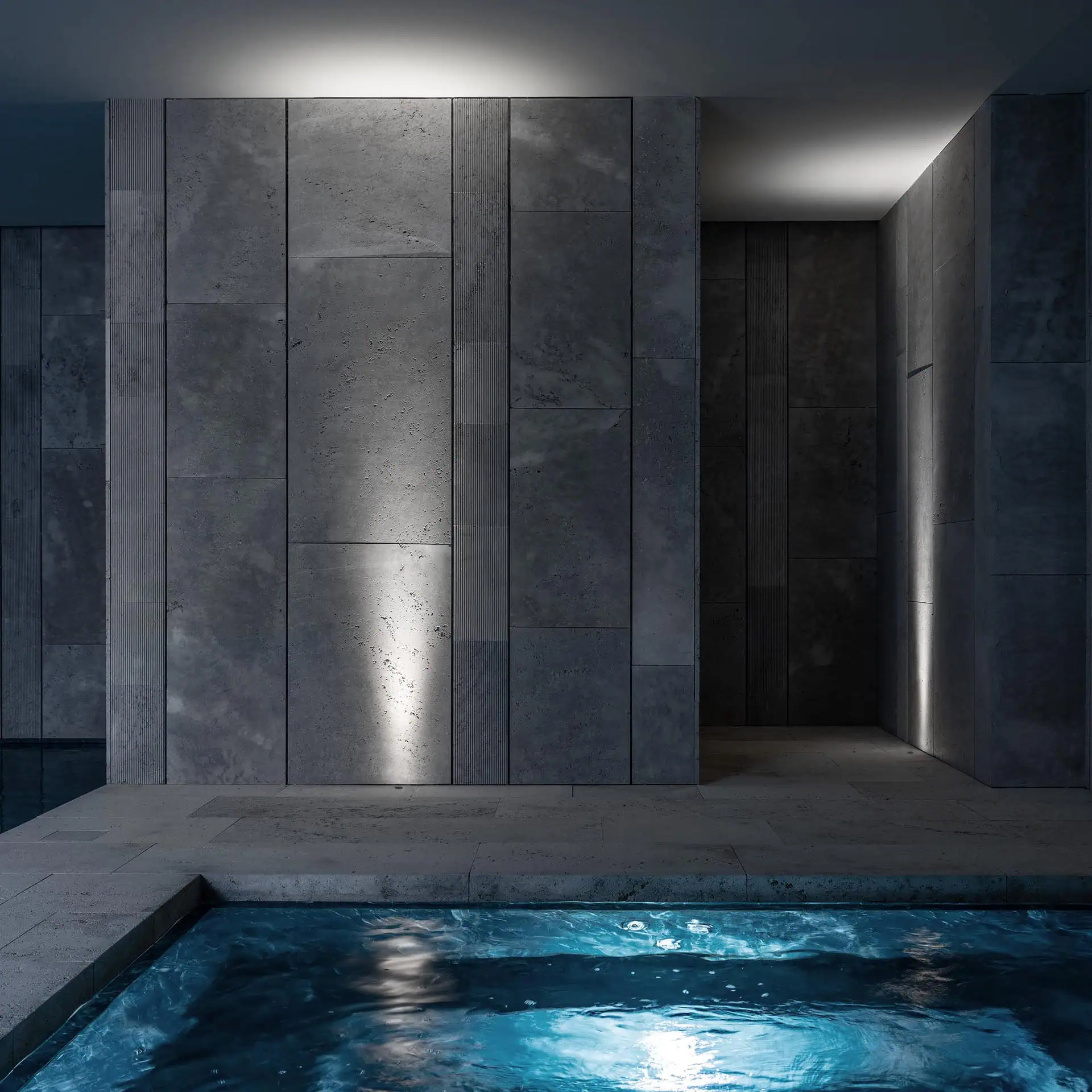 Elegant indoor swimming pool area at Villa TAI Sotogrande, showcasing architectural lighting and textured stone walls by ARK Architects and Davide Groppi.