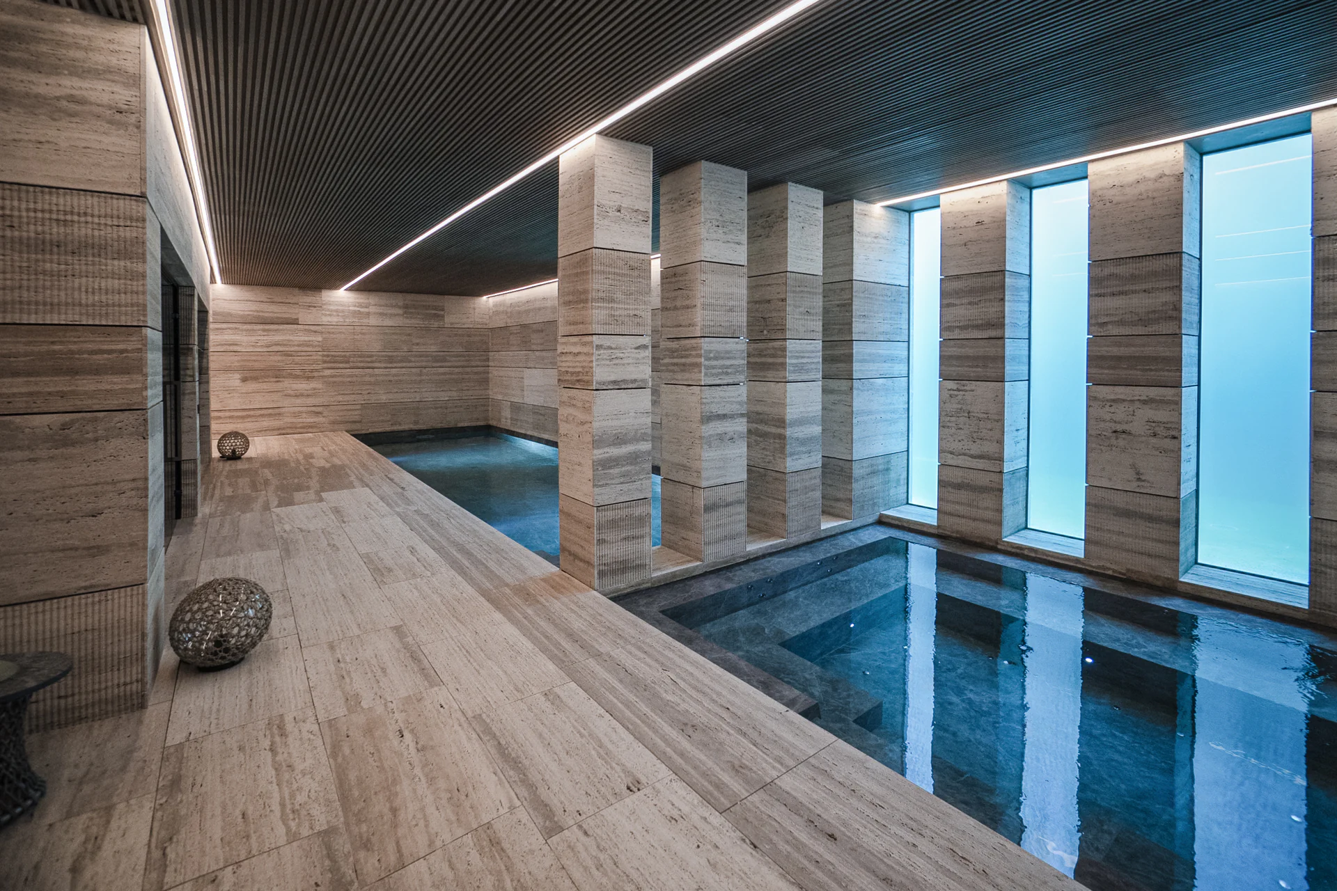 Luxury indoor spa at Villa Geneve designed by ARK Architects, featuring natural stone columns and therapeutic lighting