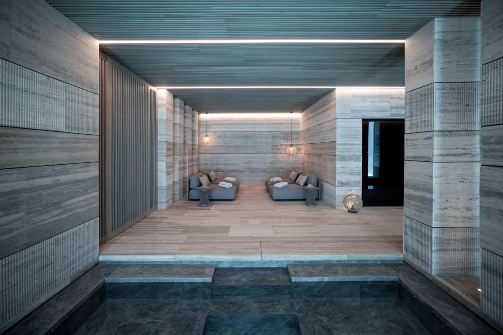 Villa Geneve luxury interior design loungers travertine walls and ambient lighting in spa La Zagaleta by ARK Architects